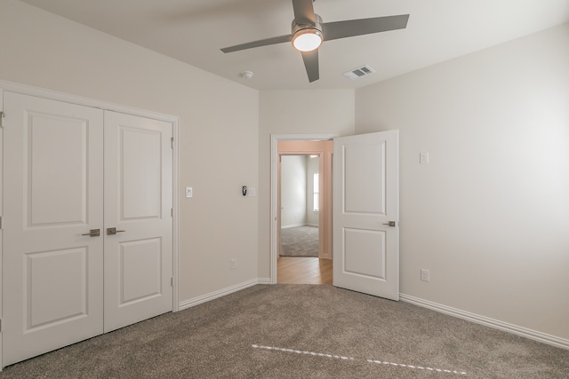 unfurnished bedroom featuring ceiling fan, light colored carpet, and a closet