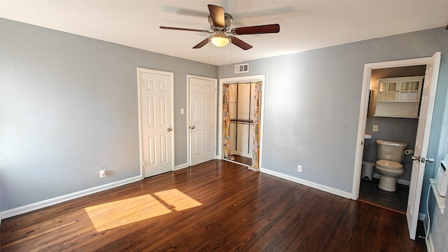 unfurnished bedroom with ceiling fan, dark wood-type flooring, and connected bathroom