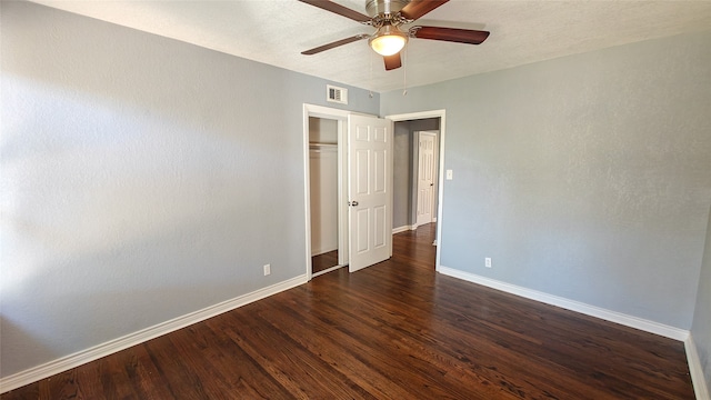 unfurnished bedroom with a closet, dark hardwood / wood-style floors, and ceiling fan