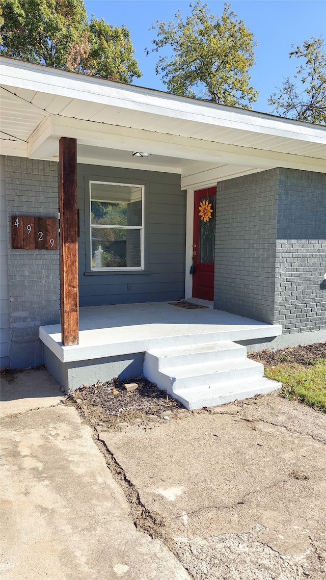 view of exterior entry with a porch