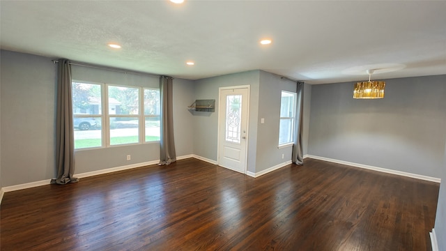 spare room with dark wood-type flooring and a wealth of natural light