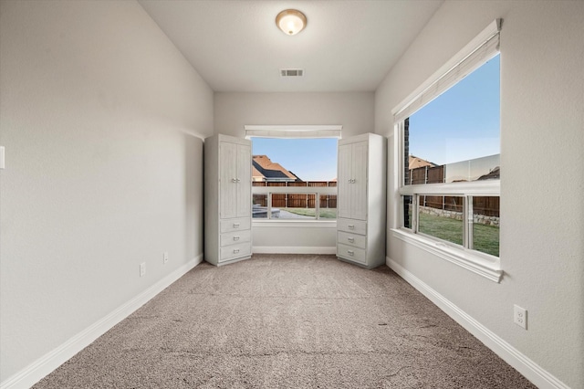 unfurnished room featuring baseboards, visible vents, and carpet floors