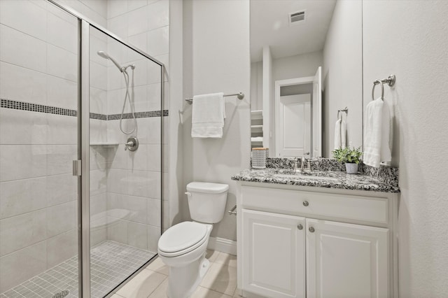 bathroom with tile patterned flooring, vanity, toilet, and a shower with shower door