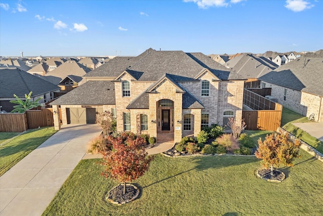 french country inspired facade with driveway, a residential view, fence, brick siding, and a front lawn