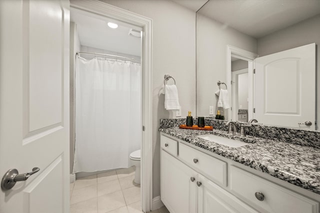 bathroom featuring tile patterned floors, vanity, toilet, and walk in shower