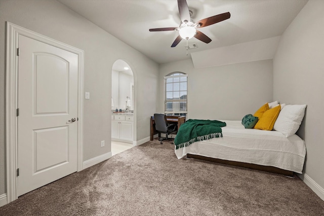bedroom featuring a ceiling fan, visible vents, baseboards, light colored carpet, and ensuite bathroom