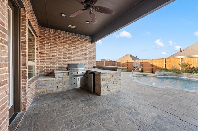 view of patio with area for grilling, pool water feature, ceiling fan, grilling area, and a fenced in pool