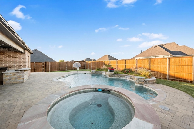 view of swimming pool with a patio area, a pool with connected hot tub, and a fenced backyard