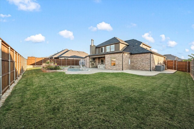 back of house with brick siding, a yard, a fenced backyard, and a patio area