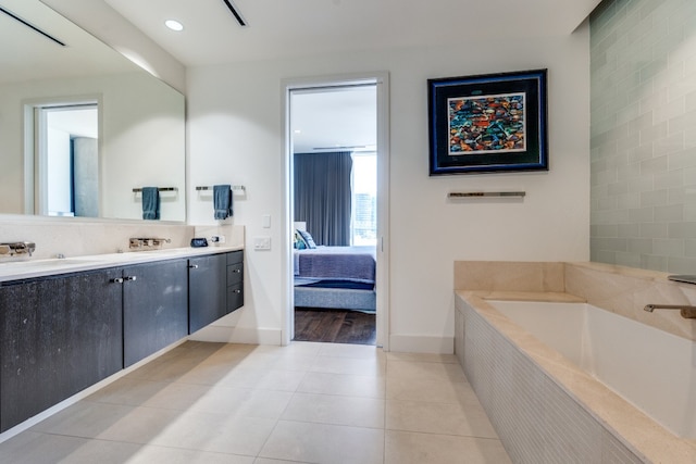 bathroom with vanity, tile patterned floors, and tiled tub