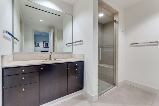 bathroom with tile patterned floors, a shower with door, and vanity