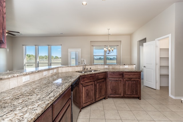 kitchen featuring dishwasher, sink, light stone counters, plenty of natural light, and ceiling fan with notable chandelier