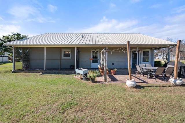 rear view of property featuring a lawn and a patio area