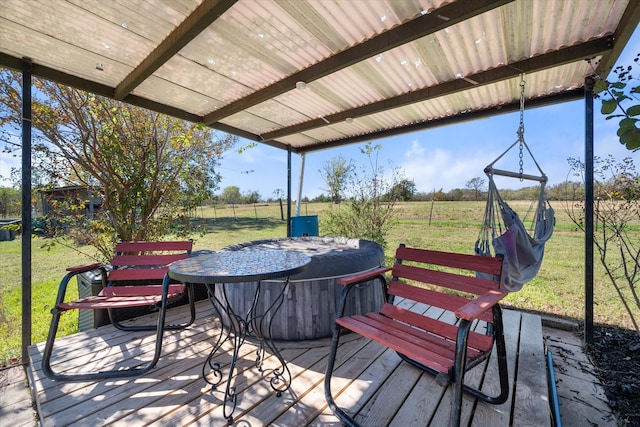 wooden deck with a hot tub, a yard, and a rural view