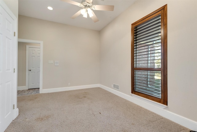 unfurnished room with light colored carpet and ceiling fan