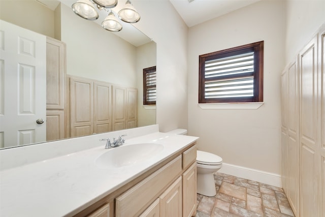 bathroom with vanity, a notable chandelier, and toilet