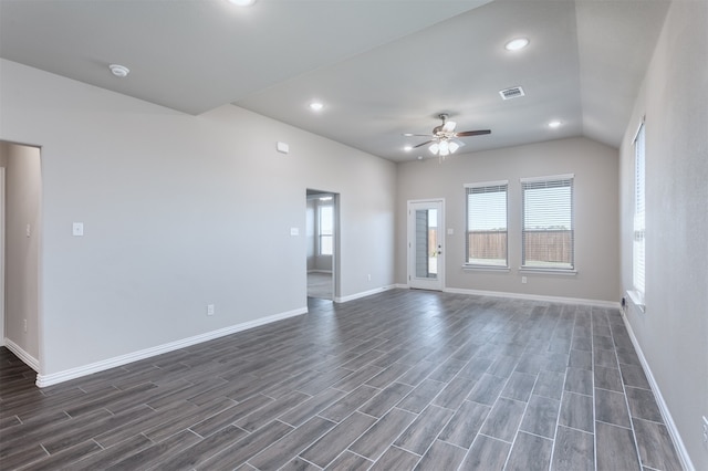 empty room with dark hardwood / wood-style flooring, vaulted ceiling, and ceiling fan