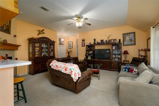 carpeted living room with ceiling fan and lofted ceiling