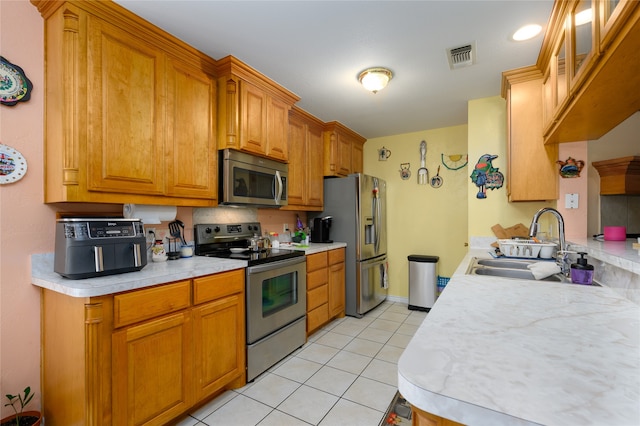 kitchen with sink, light tile patterned floors, and stainless steel appliances