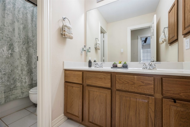 bathroom with toilet, vanity, and tile patterned floors