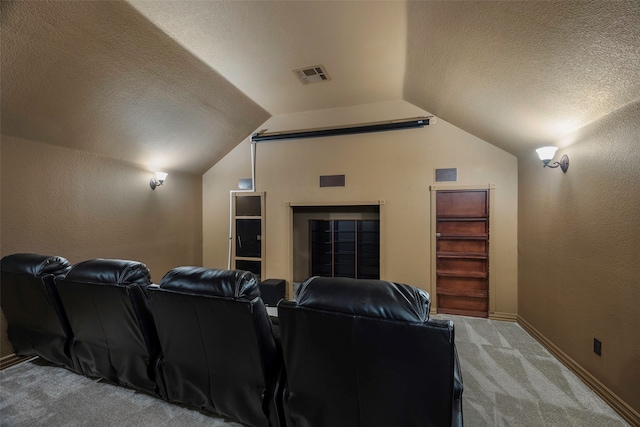 carpeted home theater room featuring a textured ceiling and vaulted ceiling