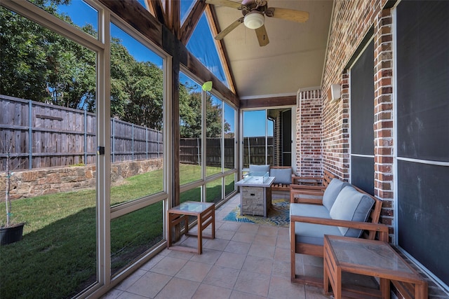 unfurnished sunroom with ceiling fan, a wealth of natural light, and vaulted ceiling