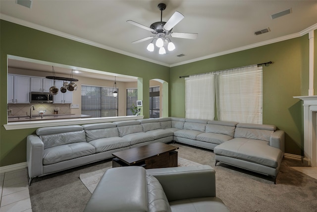 tiled living room with ceiling fan and ornamental molding