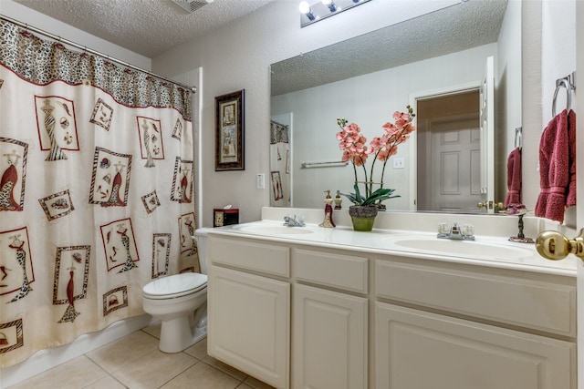 bathroom with tile patterned flooring, vanity, a textured ceiling, and toilet