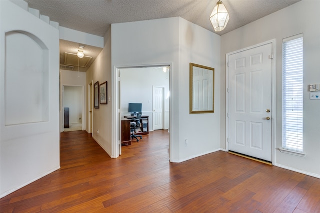 entryway with a textured ceiling and dark hardwood / wood-style flooring