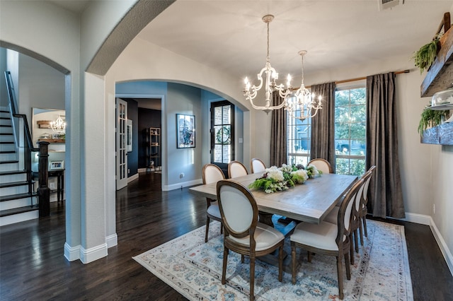 dining space with arched walkways, a chandelier, baseboards, stairs, and dark wood finished floors