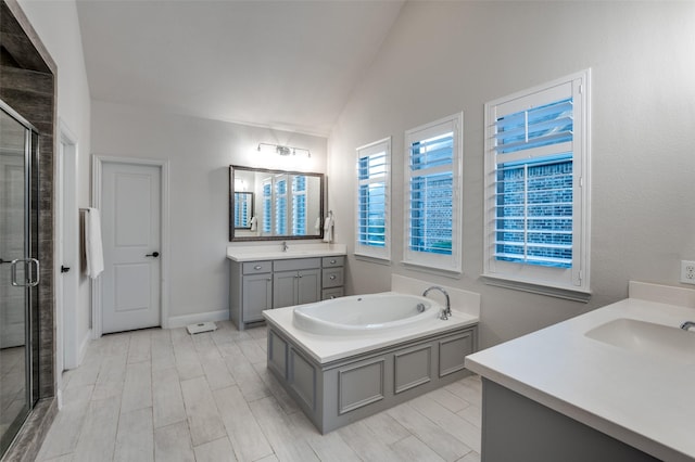 bathroom with plus walk in shower, hardwood / wood-style floors, vanity, and lofted ceiling