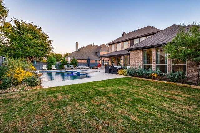 view of swimming pool featuring outdoor lounge area, a patio area, and a lawn