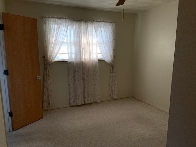 unfurnished room with ceiling fan and light colored carpet