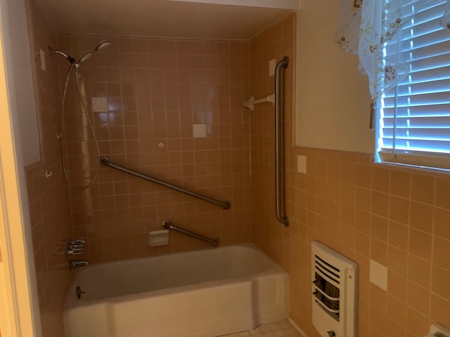 bathroom with tiled shower / bath, heating unit, and tile walls