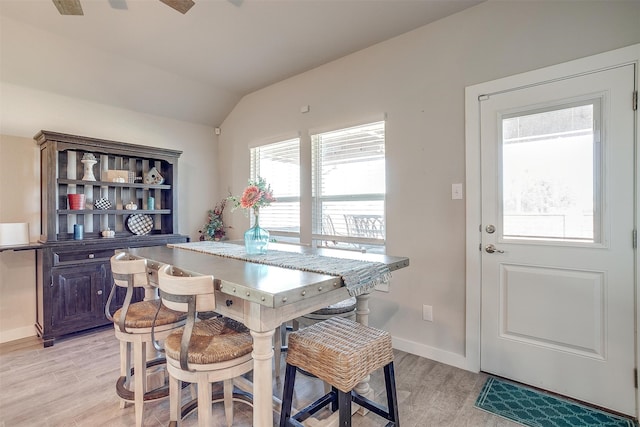 dining room with ceiling fan, light hardwood / wood-style flooring, and lofted ceiling