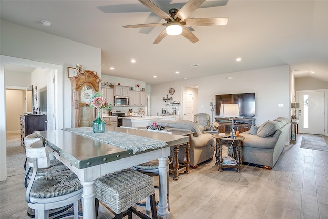 kitchen with white cabinetry, light hardwood / wood-style flooring, ceiling fan, and stainless steel appliances