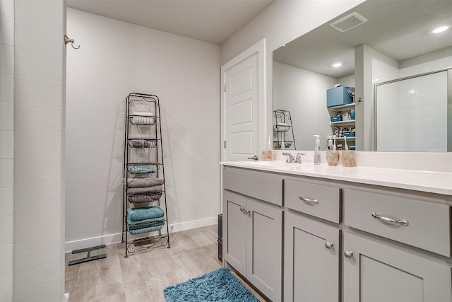 bathroom featuring vanity, wood-type flooring, and an enclosed shower