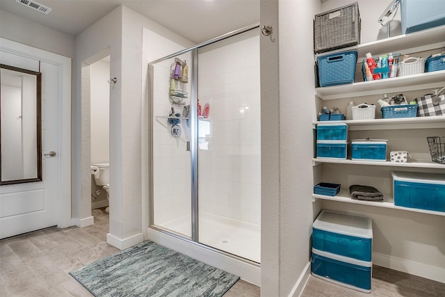 bathroom with toilet and an enclosed shower