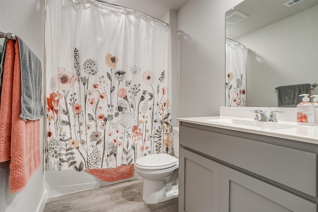 bathroom featuring toilet, vanity, and hardwood / wood-style flooring