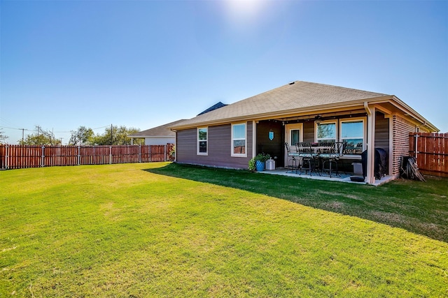 rear view of property with a lawn and a patio