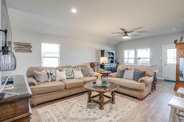 living room featuring ceiling fan, light hardwood / wood-style floors, and lofted ceiling