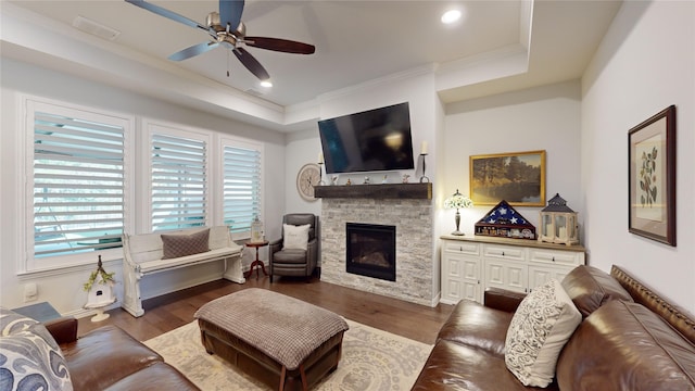 living room with dark hardwood / wood-style floors, a healthy amount of sunlight, ornamental molding, and a fireplace