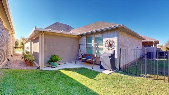 back of house with a yard and a patio