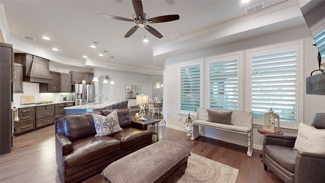 living room featuring crown molding, ceiling fan, dark wood-type flooring, and sink