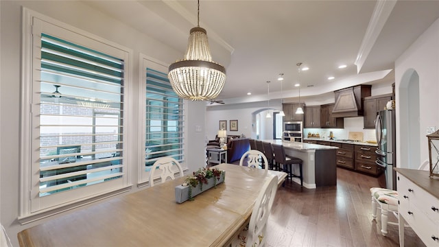 dining room featuring crown molding, dark wood-type flooring, and a notable chandelier