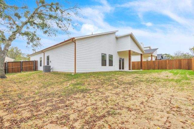 back of property with cooling unit and a yard