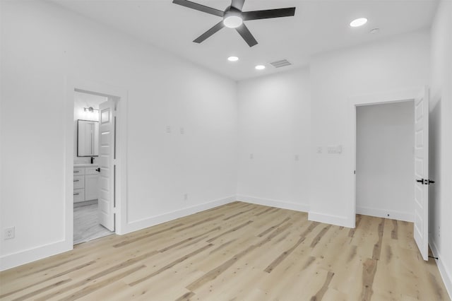 unfurnished bedroom featuring ensuite bath, ceiling fan, and light hardwood / wood-style floors