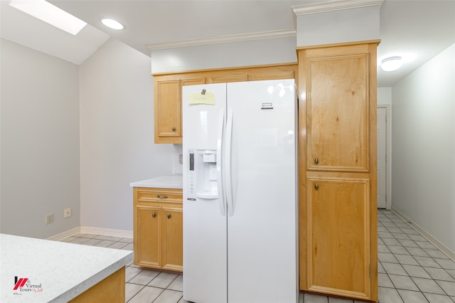 kitchen featuring white refrigerator with ice dispenser, light brown cabinetry, lofted ceiling with skylight, and light tile patterned flooring