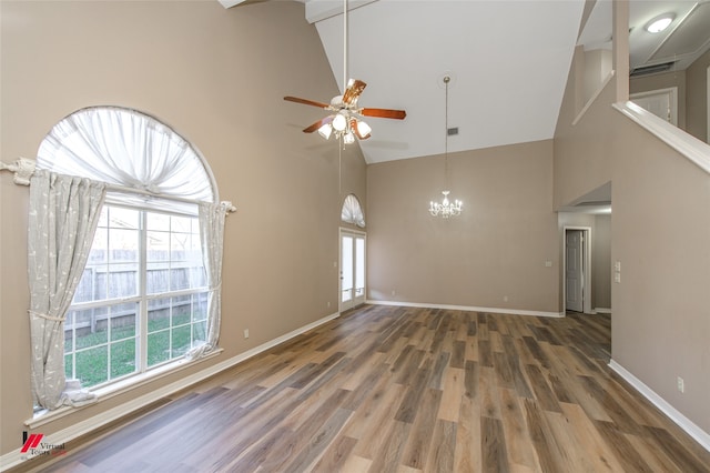 unfurnished living room with dark wood-type flooring, high vaulted ceiling, and a healthy amount of sunlight