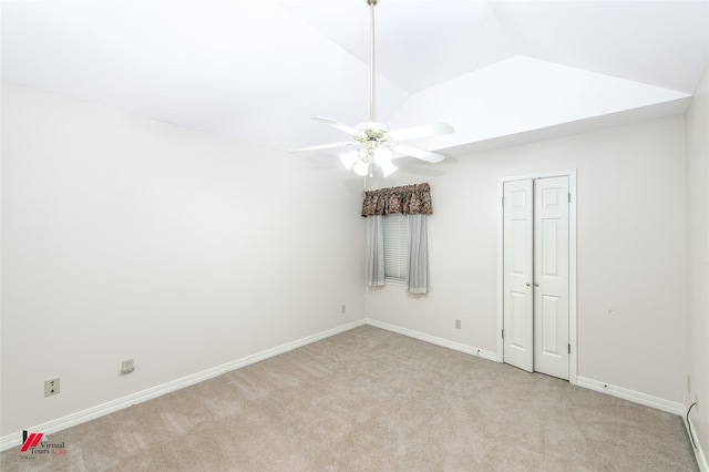 unfurnished bedroom featuring light carpet, a closet, ceiling fan, and lofted ceiling